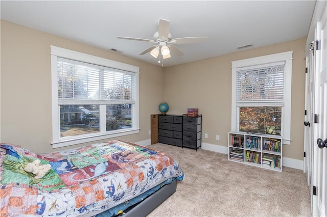 carpeted bedroom with multiple windows and ceiling fan