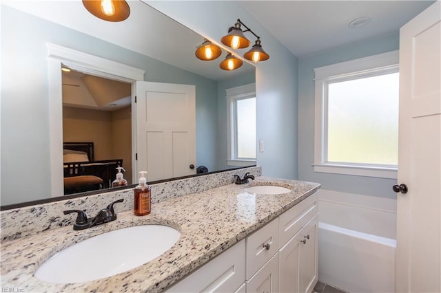 bathroom featuring a bathtub, vanity, and vaulted ceiling