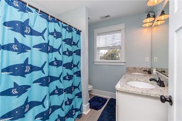 bathroom featuring curtained shower, vanity, and toilet