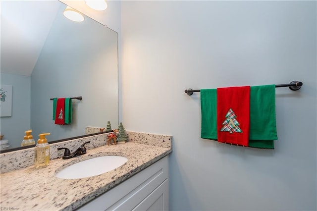 bathroom with vanity and lofted ceiling