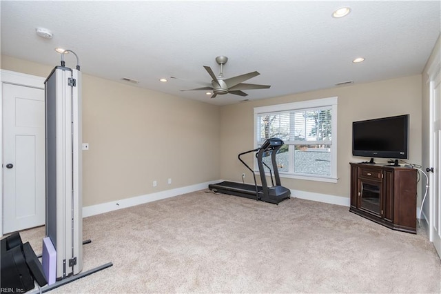 exercise room with ceiling fan and light colored carpet