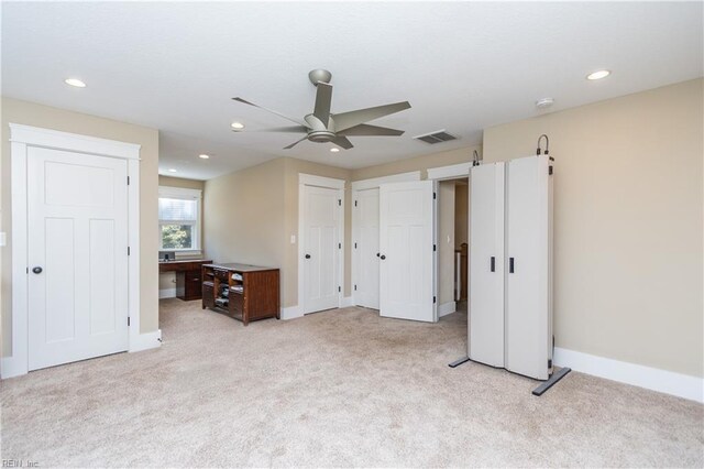 unfurnished bedroom featuring ceiling fan and light colored carpet