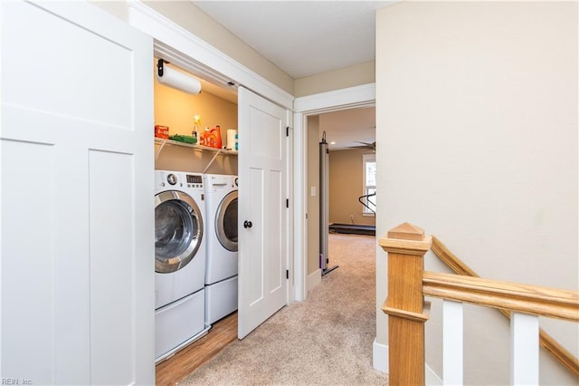 laundry room featuring ceiling fan, washing machine and dryer, and light carpet