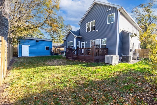 rear view of house with an outdoor structure, a lawn, a wooden deck, and central air condition unit