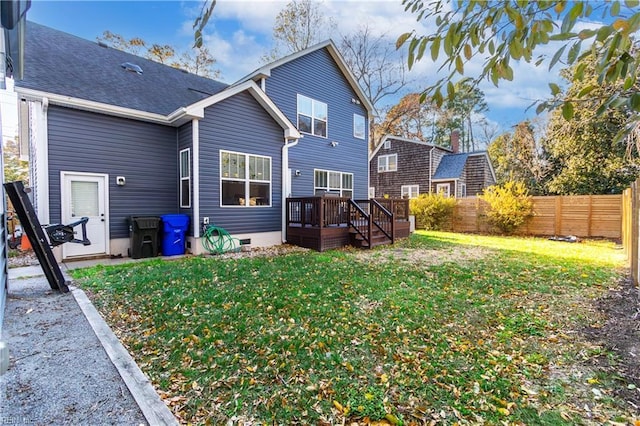 rear view of house featuring a deck and a yard