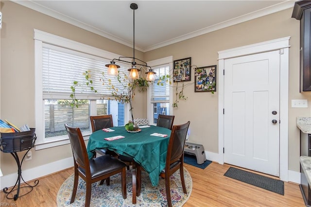 dining area with light wood-type flooring and crown molding