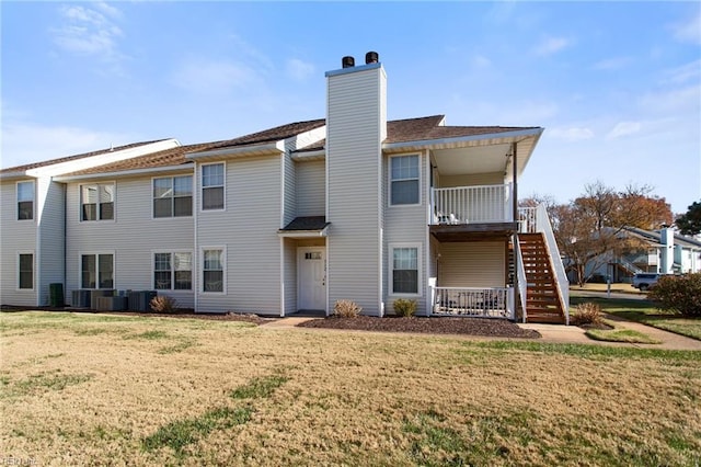 back of house with a lawn and central AC unit