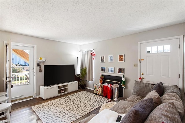 living room with a textured ceiling, hardwood / wood-style flooring, and a wealth of natural light