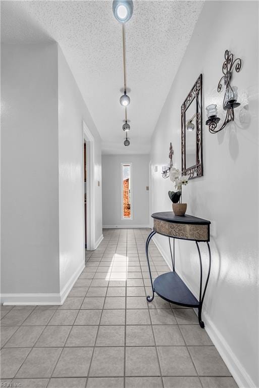 corridor featuring light tile patterned floors and a textured ceiling