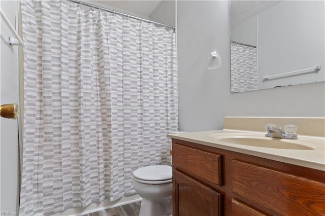 bathroom with hardwood / wood-style floors, vanity, and toilet