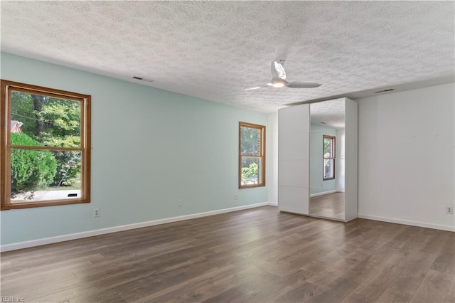 spare room with hardwood / wood-style floors, ceiling fan, and a textured ceiling