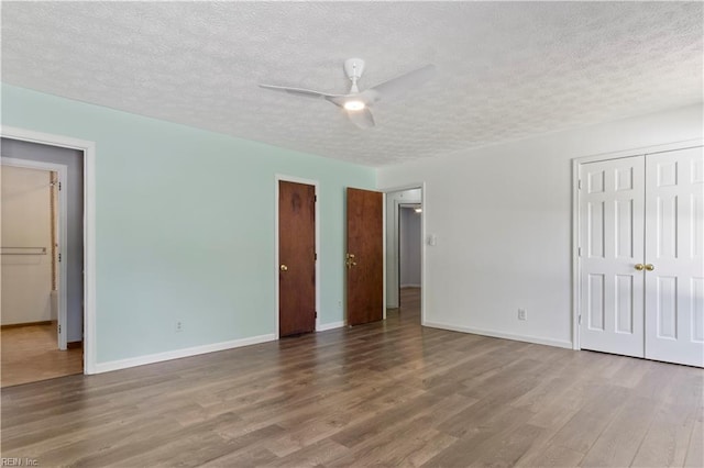 unfurnished bedroom featuring ceiling fan, hardwood / wood-style floors, and a textured ceiling