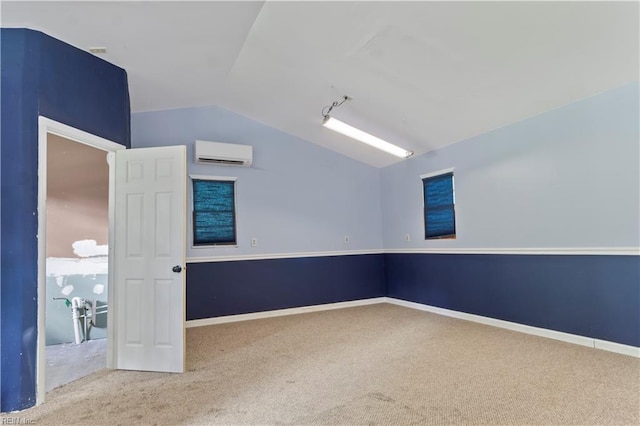 carpeted spare room with a wall mounted air conditioner and vaulted ceiling