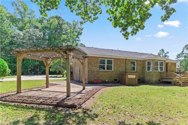 rear view of property with a pergola, a wooden deck, and a lawn