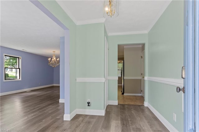 interior space with ornamental molding, a chandelier, and wood-type flooring