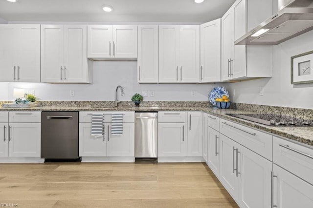 kitchen with white cabinets, light hardwood / wood-style flooring, and wall chimney exhaust hood