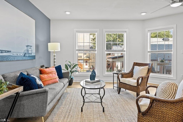 living room with ceiling fan, plenty of natural light, and light hardwood / wood-style floors