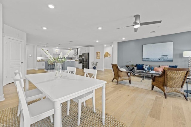 dining area with ceiling fan and light hardwood / wood-style flooring