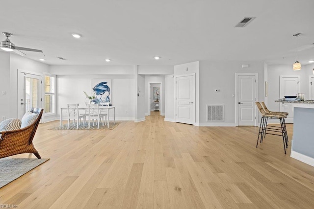 living room with ceiling fan and light hardwood / wood-style flooring