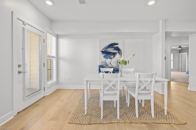 dining space with ceiling fan and light wood-type flooring