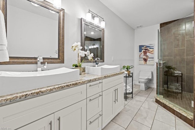 bathroom featuring vanity, toilet, and a shower with shower door