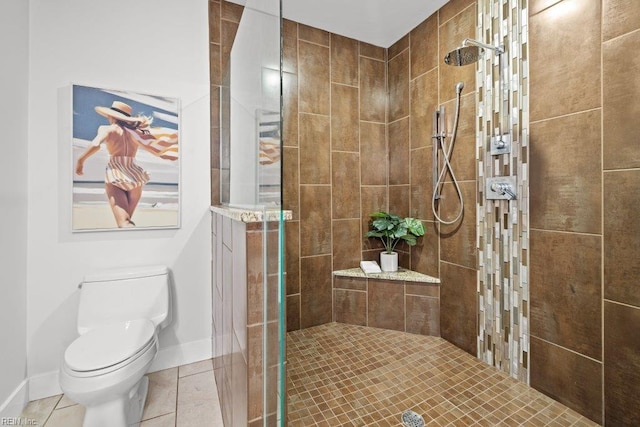 bathroom featuring tile patterned floors, toilet, and tiled shower