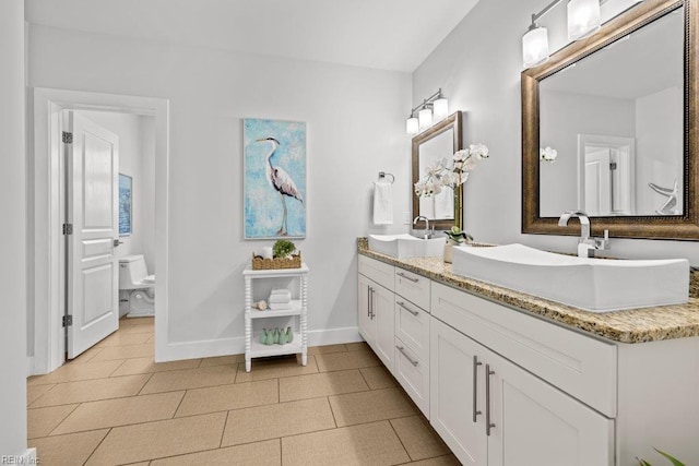 bathroom with tile patterned floors, vanity, and toilet