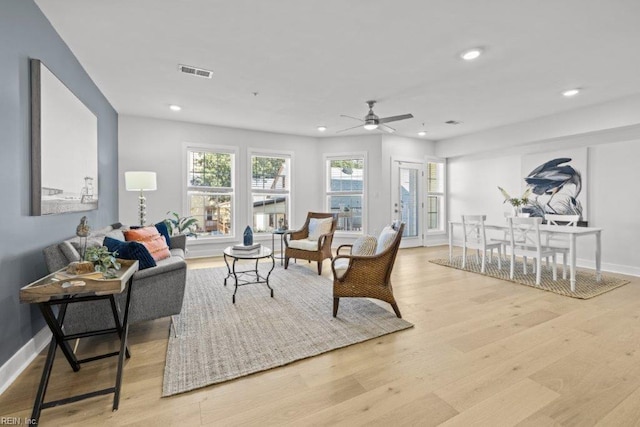 living room featuring light hardwood / wood-style flooring and ceiling fan