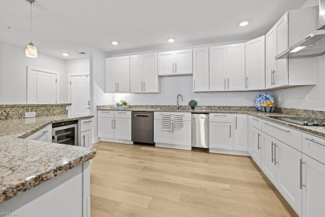 kitchen featuring white cabinets, light hardwood / wood-style floors, and wall chimney exhaust hood