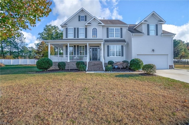 view of front of house featuring a porch, a front yard, and a garage