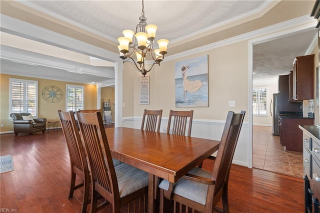 dining room with plenty of natural light, dark hardwood / wood-style flooring, ornamental molding, and a chandelier