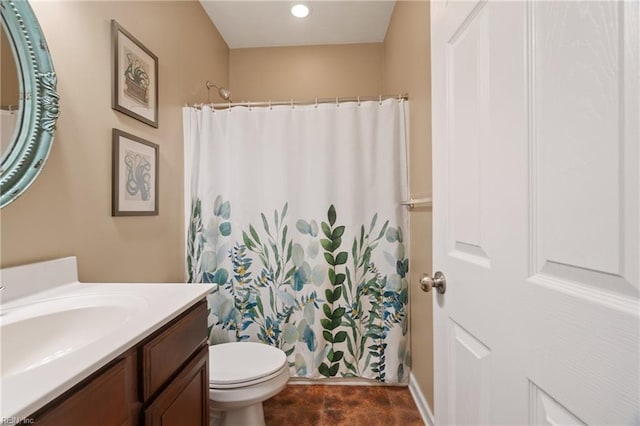 bathroom with walk in shower, vanity, and toilet