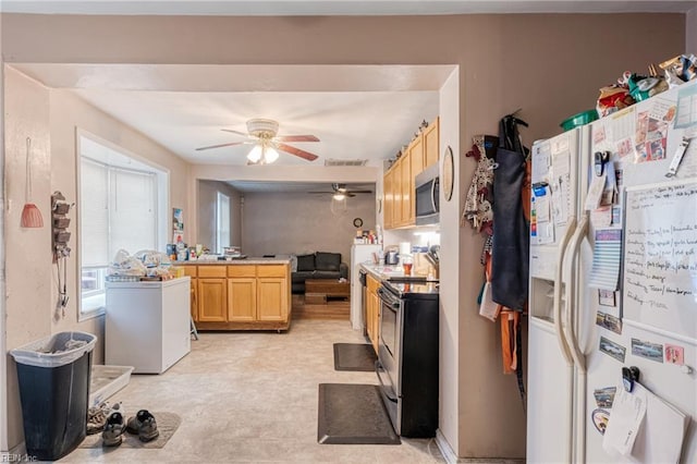 kitchen featuring kitchen peninsula, ceiling fan, light brown cabinets, and stainless steel appliances