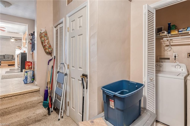 laundry area with ceiling fan, light carpet, and washer / dryer