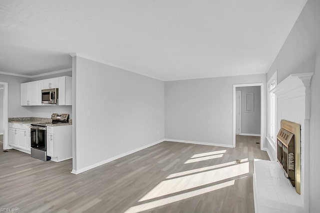 unfurnished living room featuring light wood-type flooring, crown molding, and heating unit