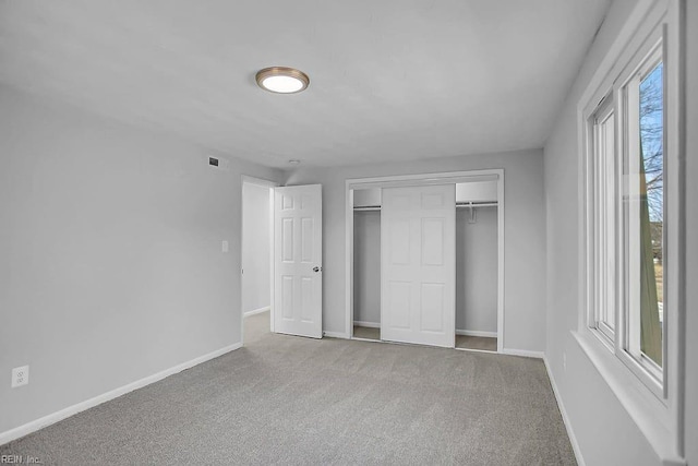 unfurnished bedroom featuring carpet flooring and a closet