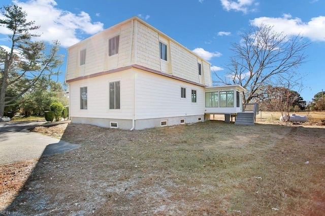 back of house featuring a wooden deck and a sunroom