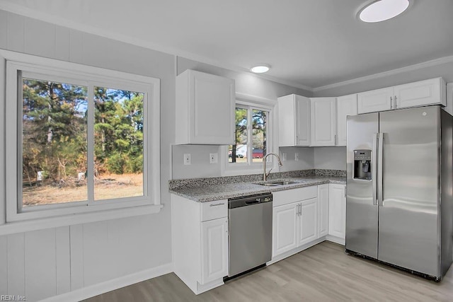 kitchen with a wealth of natural light, sink, white cabinets, and appliances with stainless steel finishes