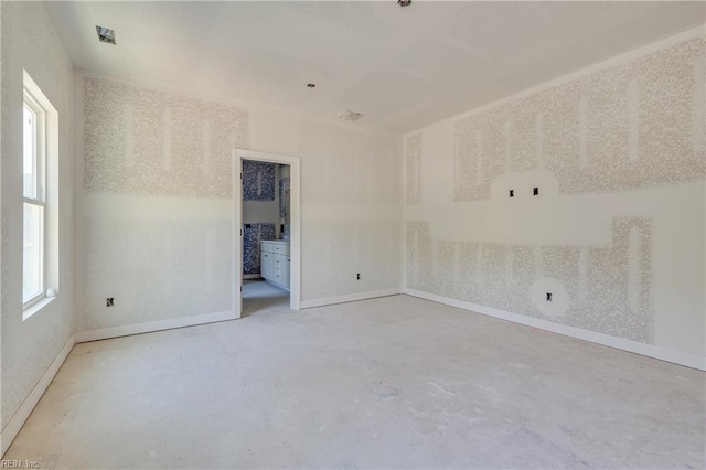 unfurnished room with baseboards