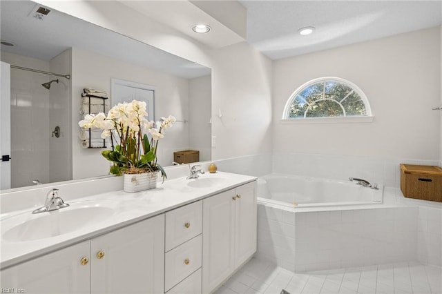 bathroom featuring tile patterned flooring, vanity, and shower with separate bathtub