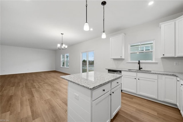 kitchen with a kitchen island, white cabinetry, and sink