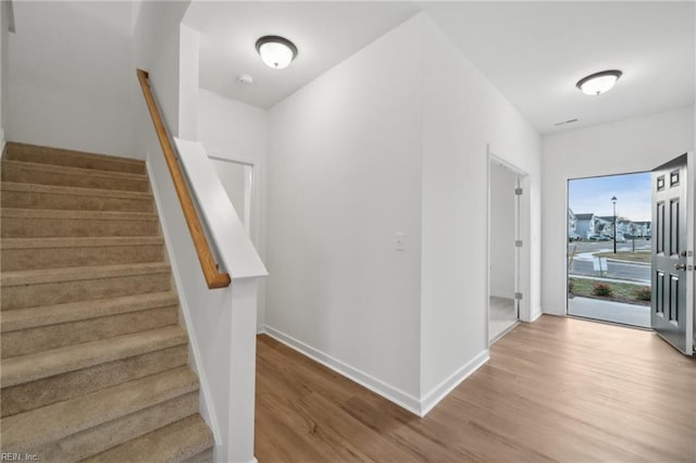 stairs with hardwood / wood-style flooring