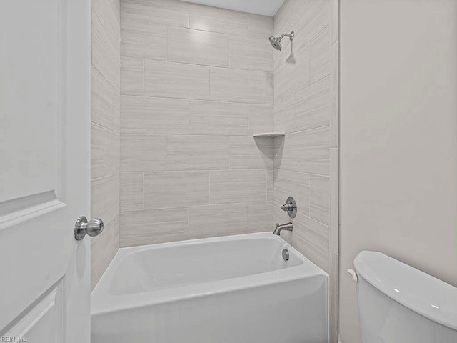 bathroom with tiled shower / bath combo and toilet