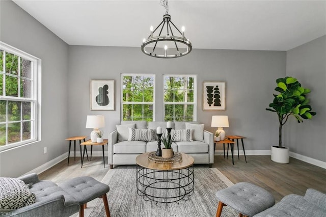 living room with hardwood / wood-style flooring, a wealth of natural light, and an inviting chandelier