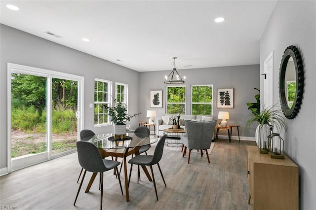 dining room featuring hardwood / wood-style flooring, a notable chandelier, and a healthy amount of sunlight