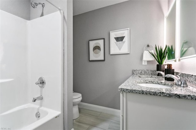 full bathroom featuring toilet, vanity, and washtub / shower combination