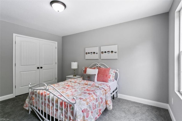 bedroom with dark colored carpet, multiple windows, and a closet