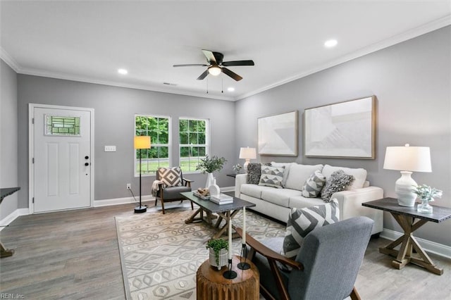 living room featuring ceiling fan, wood-type flooring, and ornamental molding