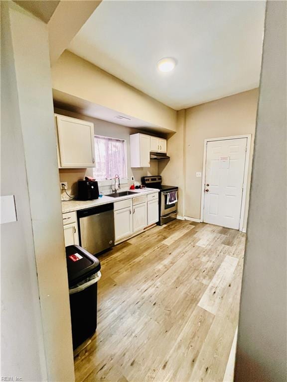 kitchen featuring sink, white cabinets, stainless steel appliances, and light hardwood / wood-style floors