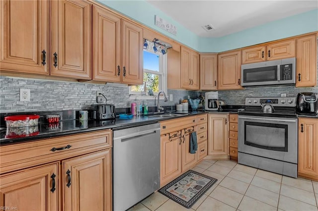 kitchen with light brown cabinetry, tasteful backsplash, stainless steel appliances, sink, and light tile patterned floors